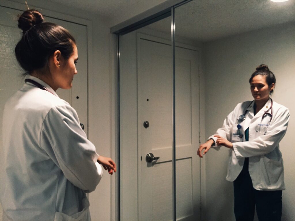 Travel Nurse In Front Of A Mirror Preparing For Duty