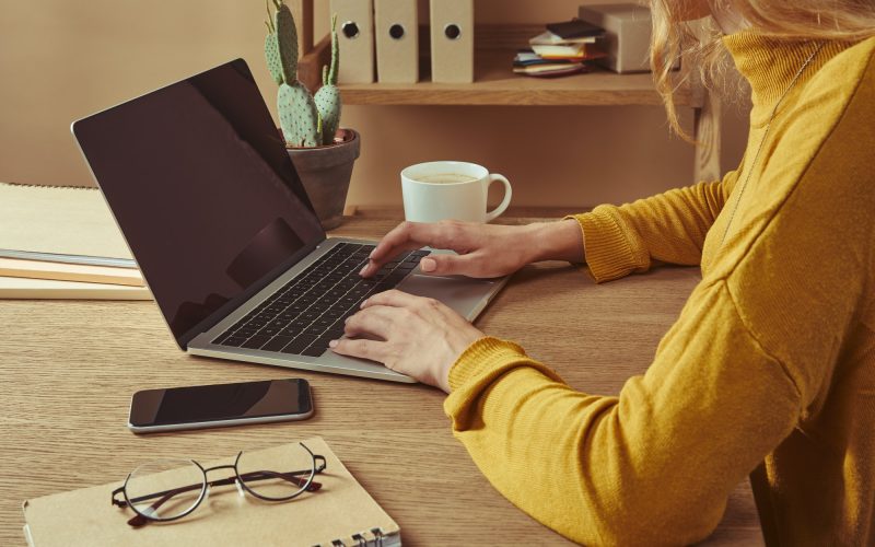 image of woman using laptop to prepare writing her resume online