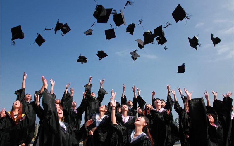 Fresh graduates throwing their caps in the air