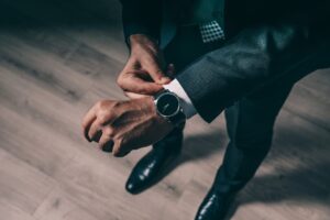 Signs of an effective leadersship is when one comes on time as signified by a man wearing a suit fixes his watch