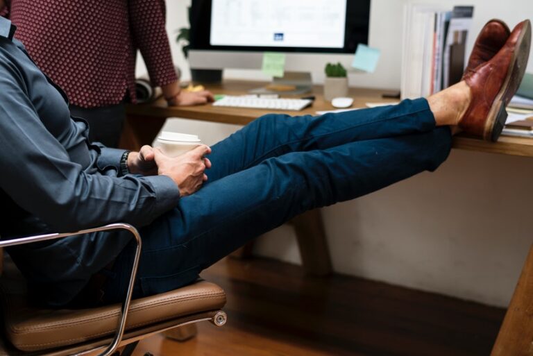 A male employee resting his feet in his desk that shows work procrastination