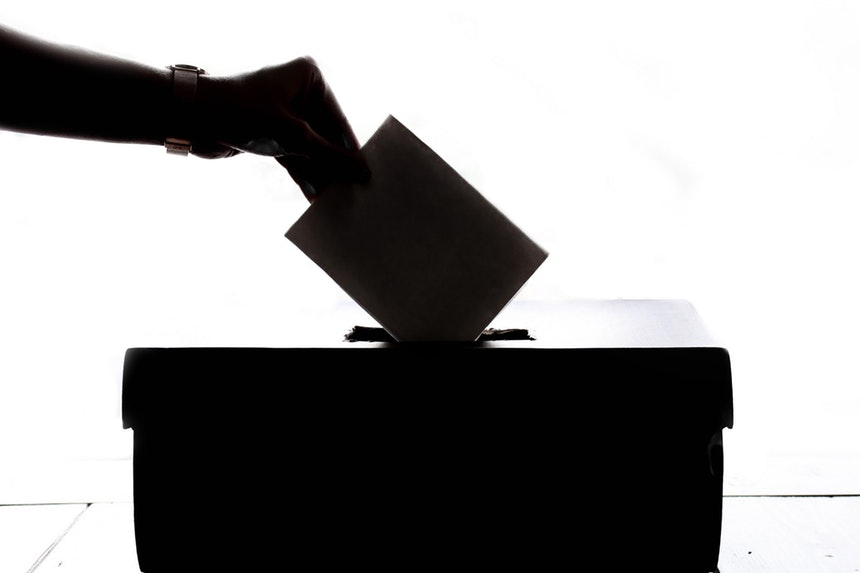 A Voter Placing His Votes In A Ballot Box.