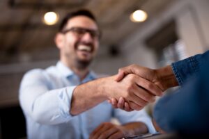 An applicant shaking the HR Manager’s hand after getting hired using the smartest questions to ask in an interview