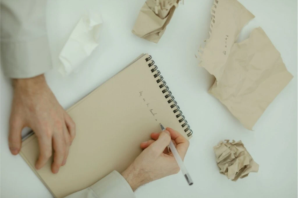 person making mistakes while writing on notepad