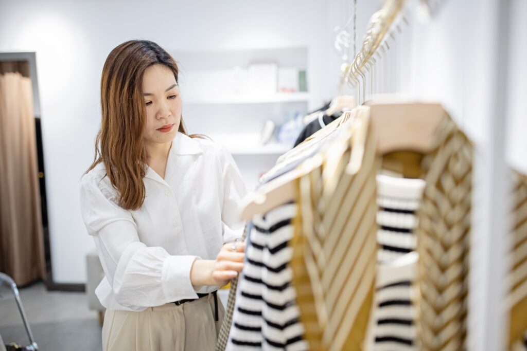 Sales Associate Working In Retail Shop Arranging Merchandise
