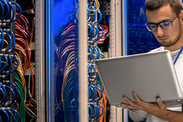 Man Holding A Laptop In Server Room