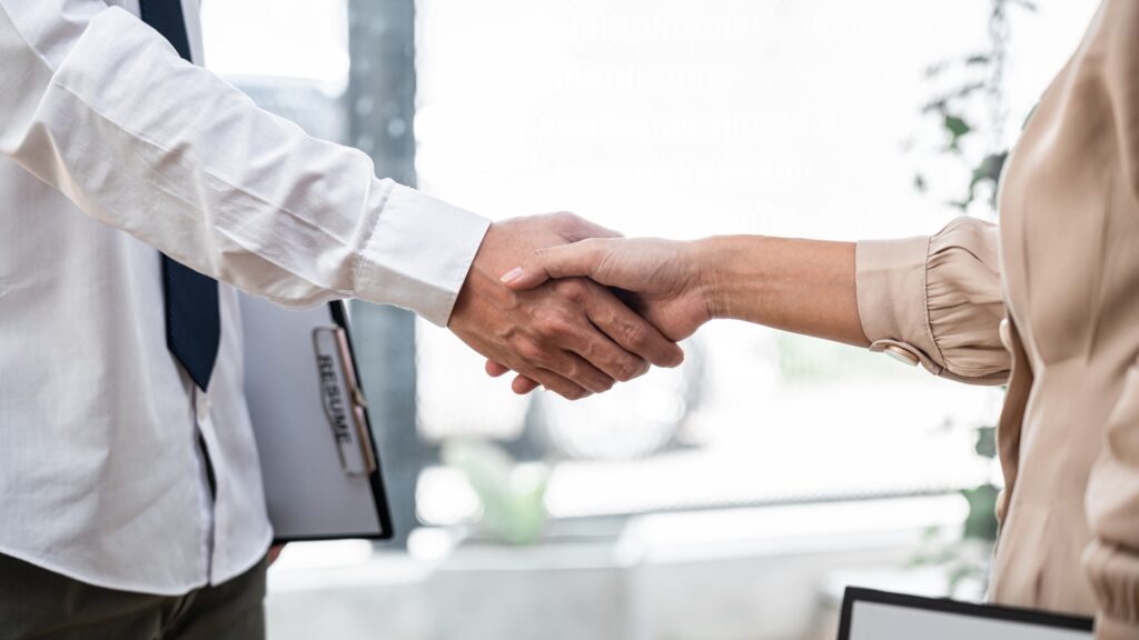 Successful Job Interview Shown By Handshake Between Hiring Manager And Job Seeker 