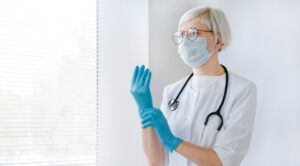 Doctor wearing gloves and thinking of is health care a good career path