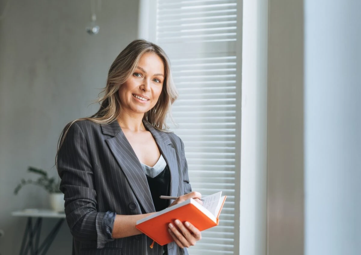 professional woman holding book smiling