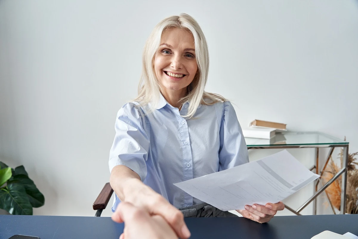 hr manager smiling holding document shake hands