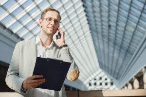 A sales manager holding documents having phone call.