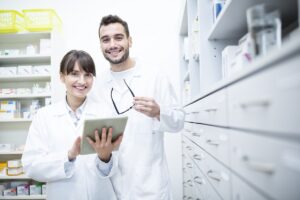 Portrait Of Two Smiling Pharmacists Holding Pharmacy Technician Resume