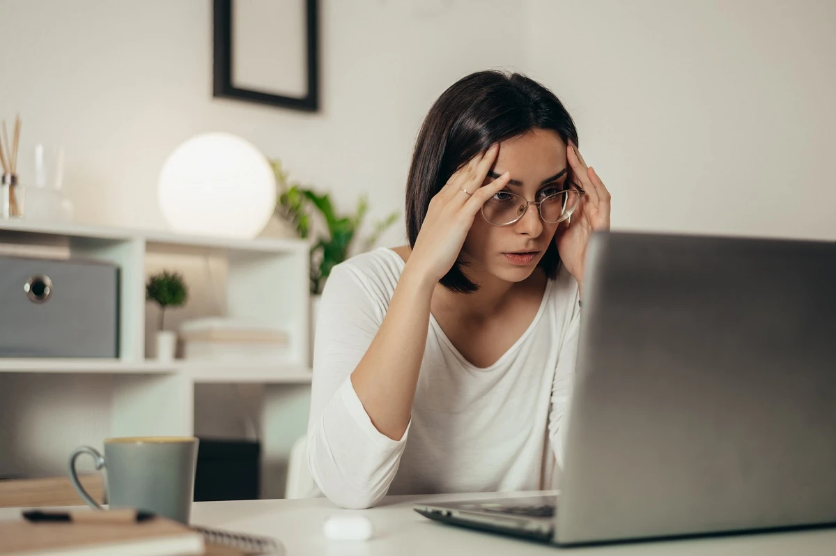 woman stressed composing email job interview reschedule