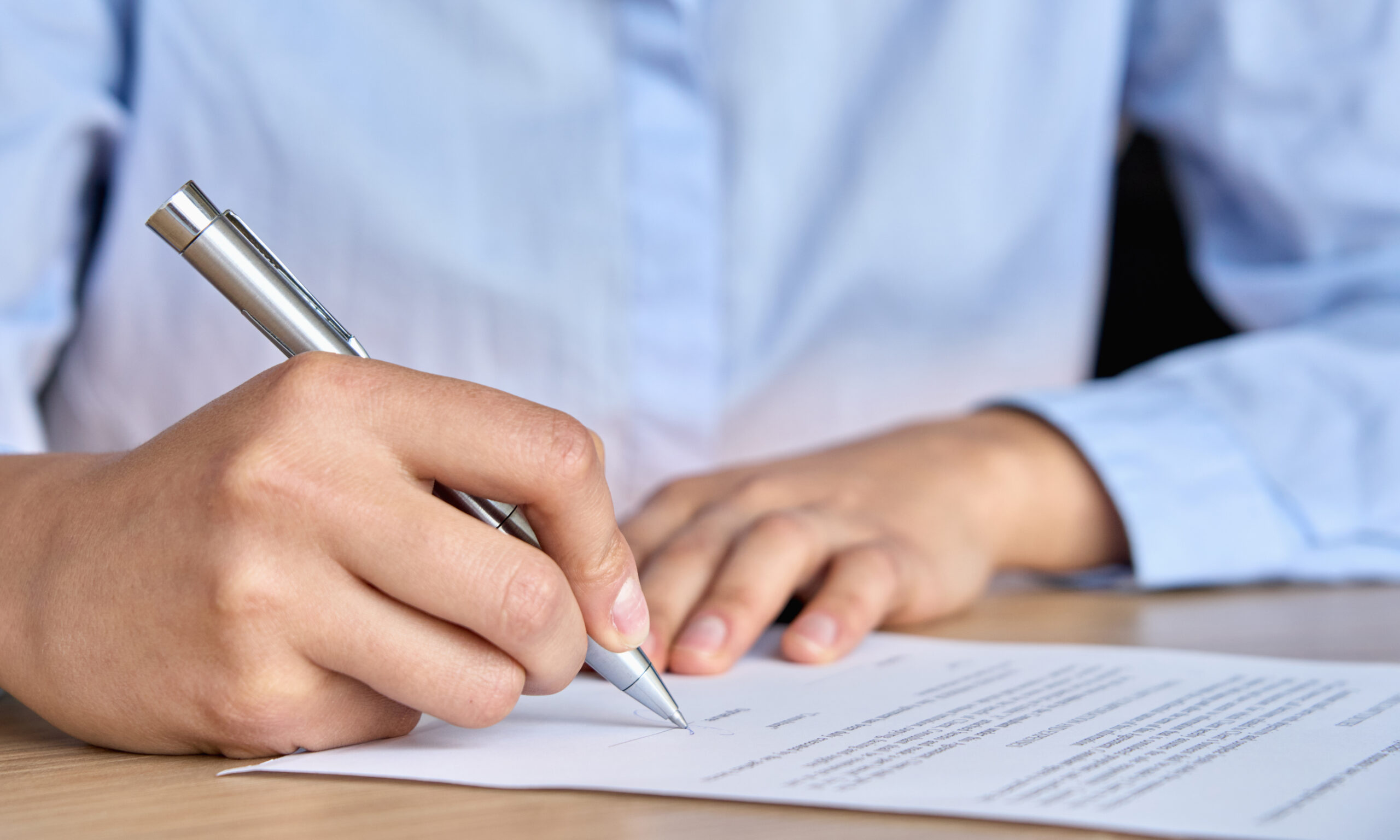 Close Up View Of Woman Hand Signing Paper