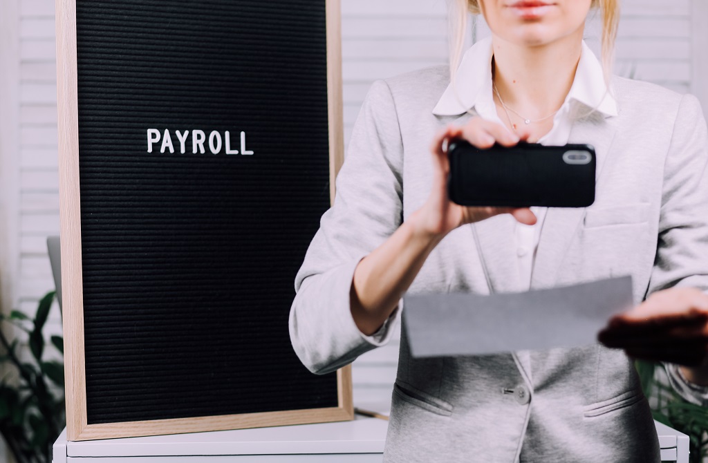 An Employee Capturing Her Payroll With A Phone
