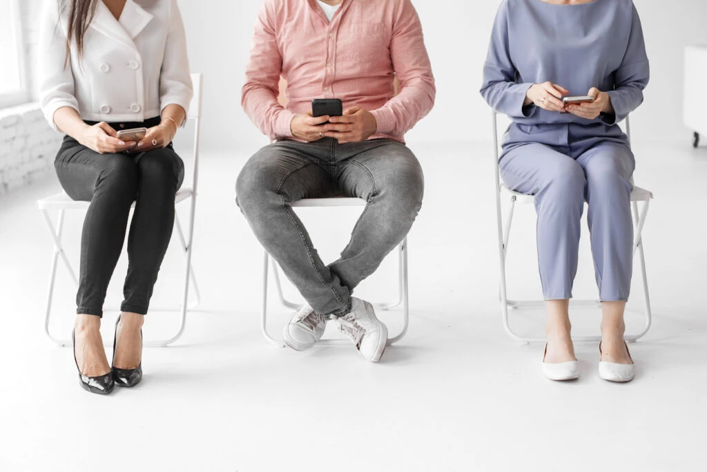 group of people sitting on chairs on a panel interview
