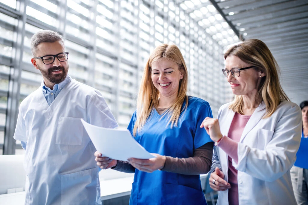 group of doctors walking in corridor holding medical resume