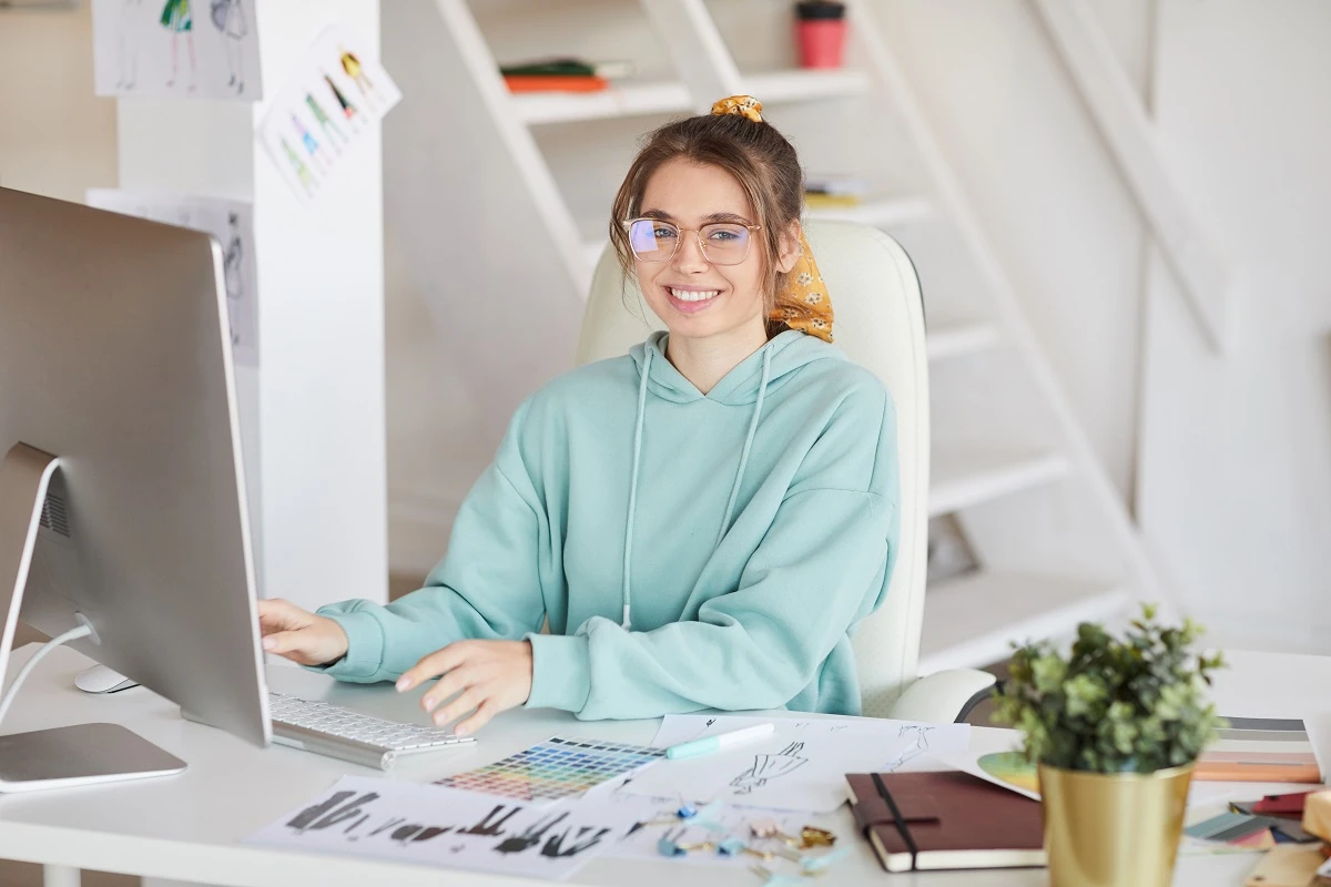 smiling female digital artist immersed in creative process working passionately on her computer