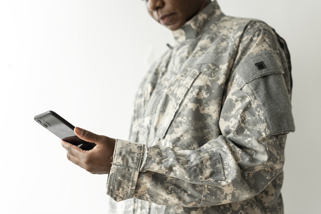 A Female Military Personnel Using Her Phone To Access Online Job Search Resources