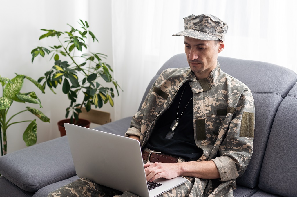 A Soldier Writing A Military-To-Civilian Resume On A Laptop