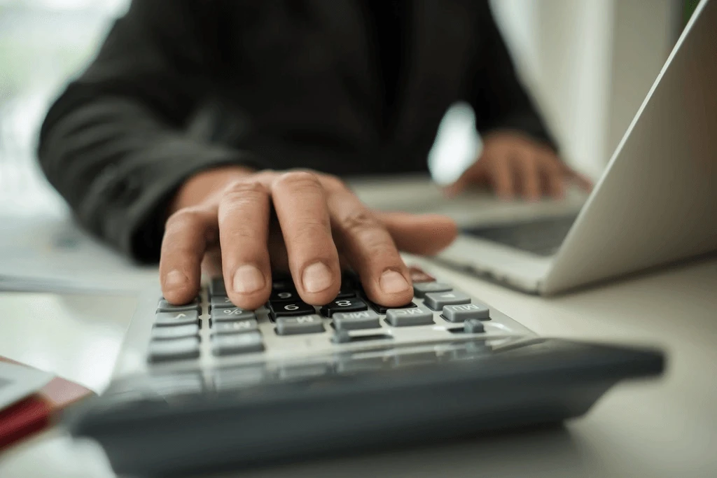 Accountant Using His Calculator At Work