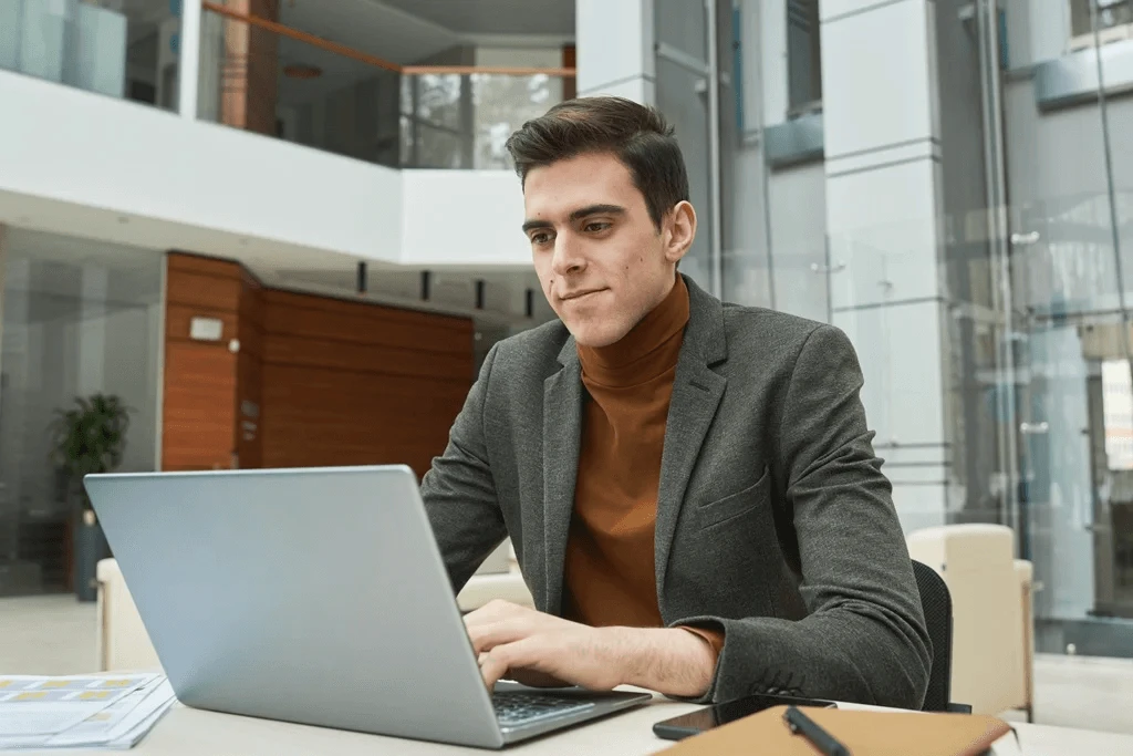 mentor writing an employee recommendation letter using his laptop