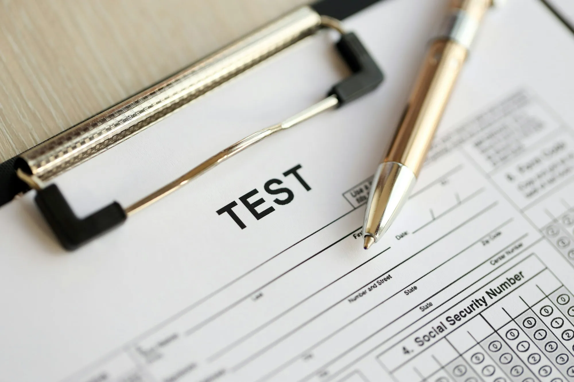 blank educational test for students lies on table in classroom with pen