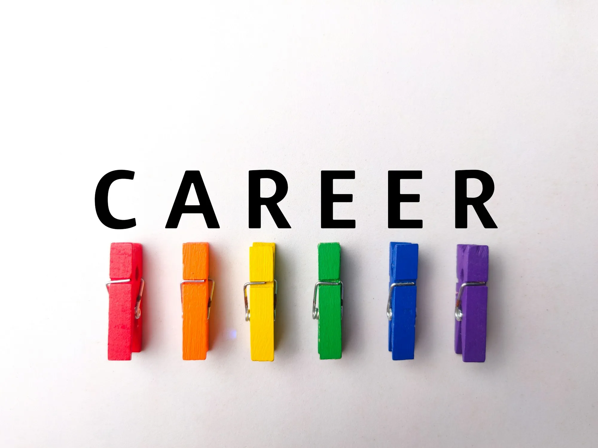 colored wooden clips with word career on a white background