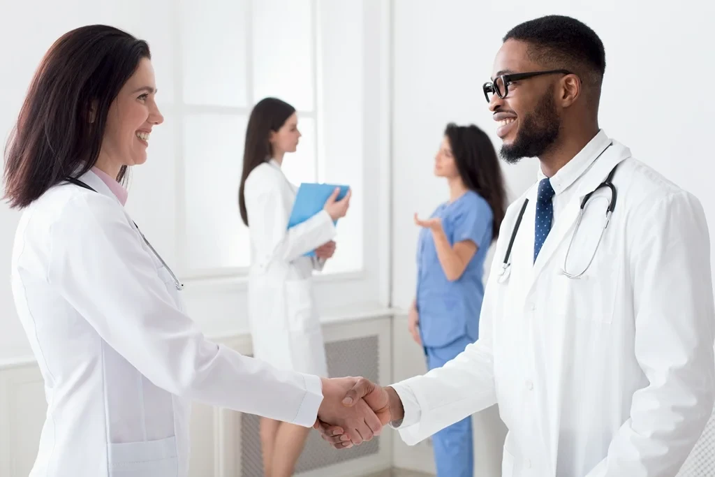 Newly Hired Physician Assistant Being Greeted By A Doctor