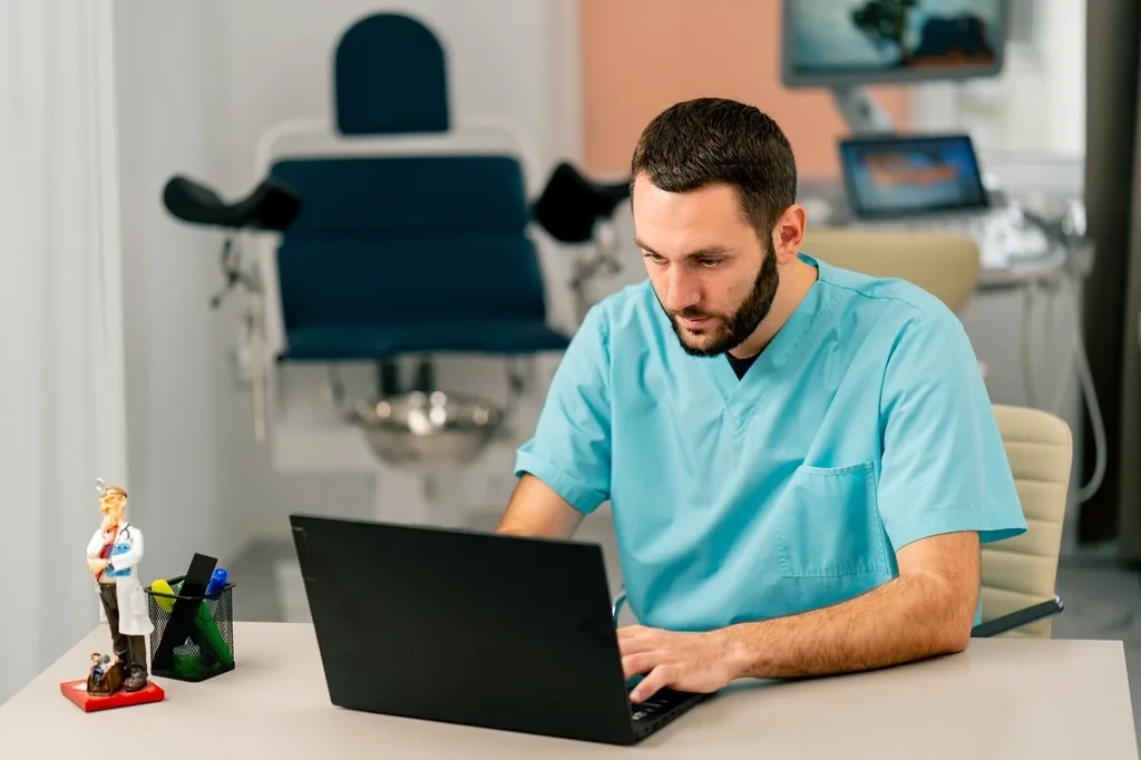 Physician Assistant Using A Laptop At Work