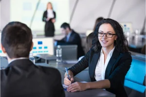 smiling interviewer reviewing job applications and noting the use of first person in a resume