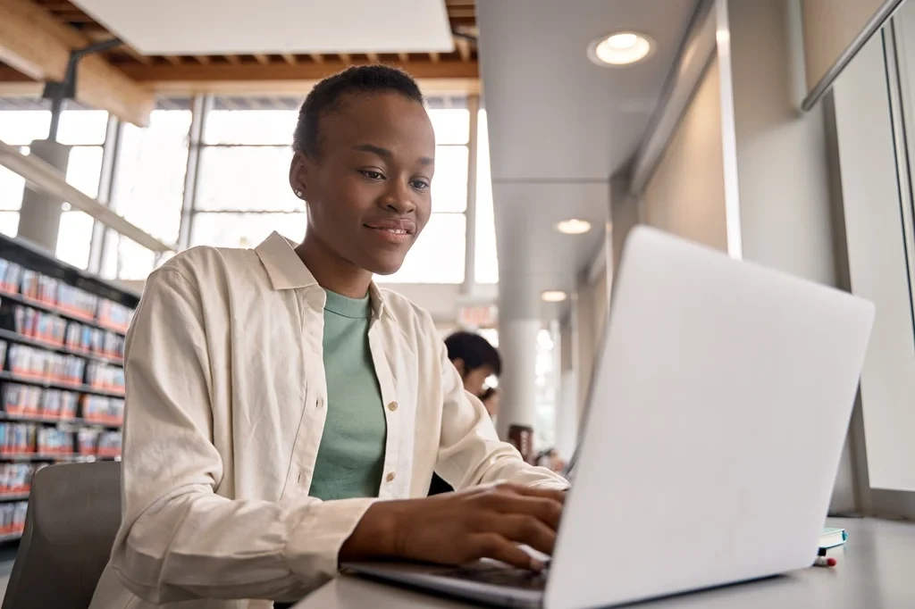 Student Optimizing Her Resume In A Library