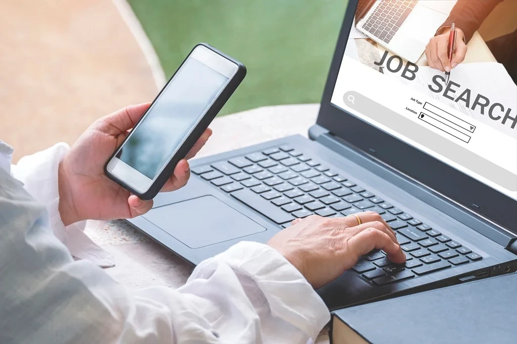Job Seeker Referencing Her Phone For Accurate Online Job Application Steps