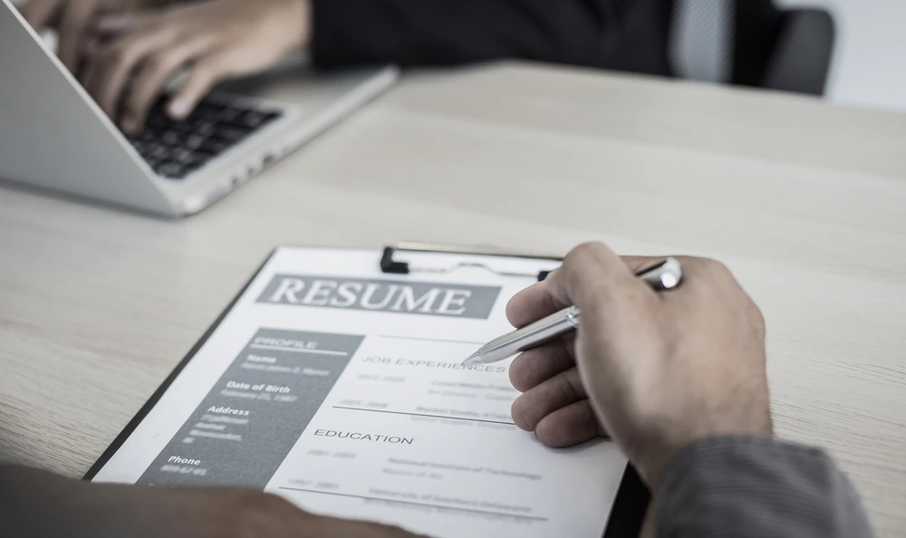 A Cropped Image Of A Man Reviewing A Resume, Symbolizing How To Quantify Achievements In Career Documents.