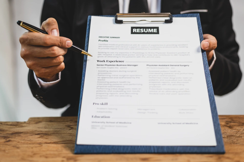 A Man Pointing To Bulleted Items On A Resume, Illustrating How To Quantify Achievements.