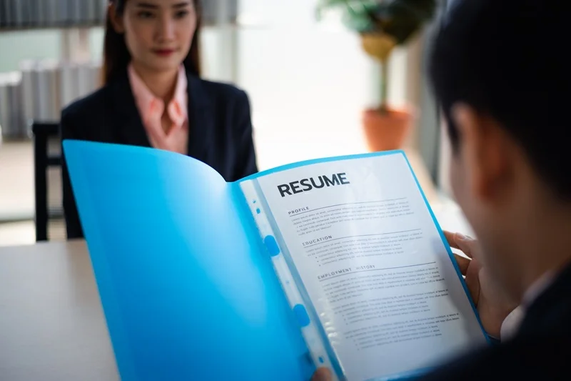 Employer Reviewing Resume During Interview For A Server Job Description