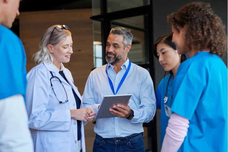 Healthcare Administrator Demonstrating Strong Healthcare Administration Skills While Leading A Team Meeting In A Hospital Setting