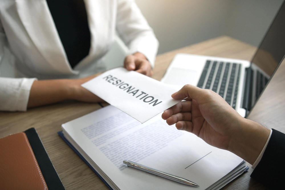Male Employee Handing A Resignation Envelope In Line With Voluntary Separation Scheme