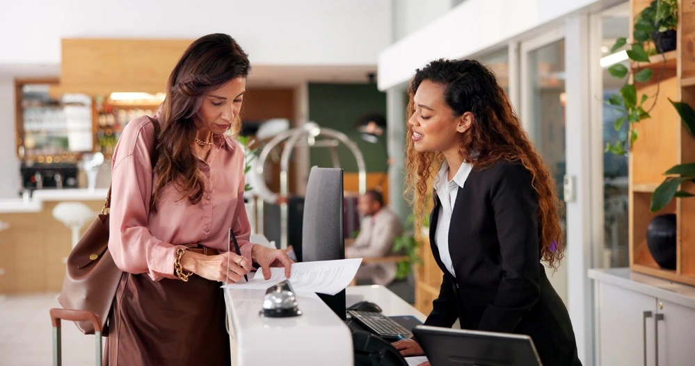 Smiling Professional Assisting A Client In A Modern Workplace Setting, Symbolizing Empathy, Trust, And ValueโWhat Does Customer Service Mean To You