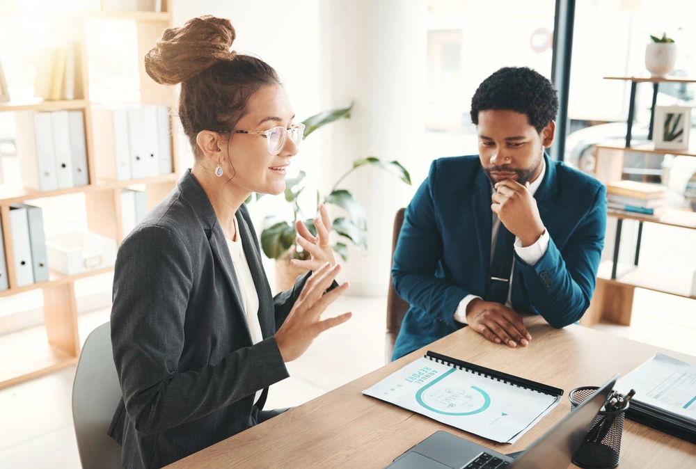 A Hiring Manager Discussing Plans And Strategies With A Colleague