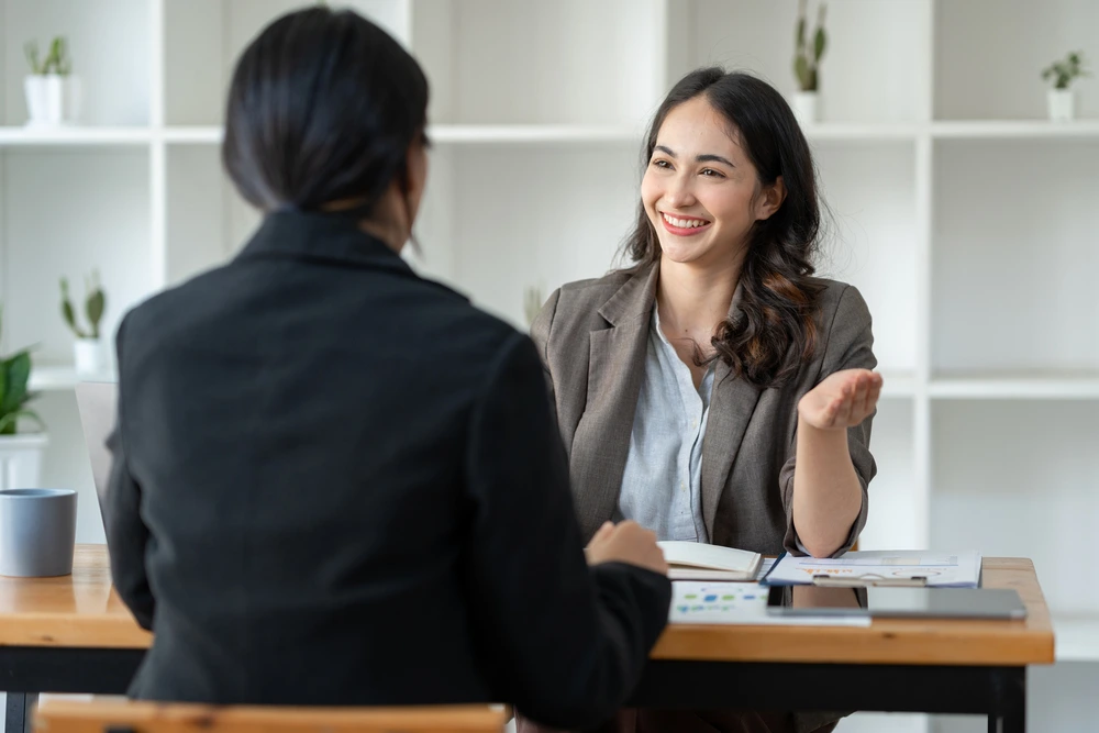A Job Applicant Enthusiastically Sharing Her Fun Facts Examples During The Interview.