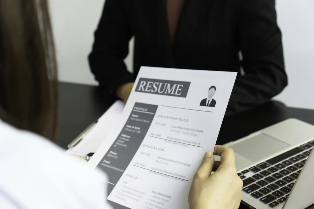 A Job Applicant Submitting A Resume During An Interview.