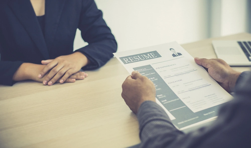A Cropped View Of A Hiring Manager Reviewing An Administrative Support Resume.