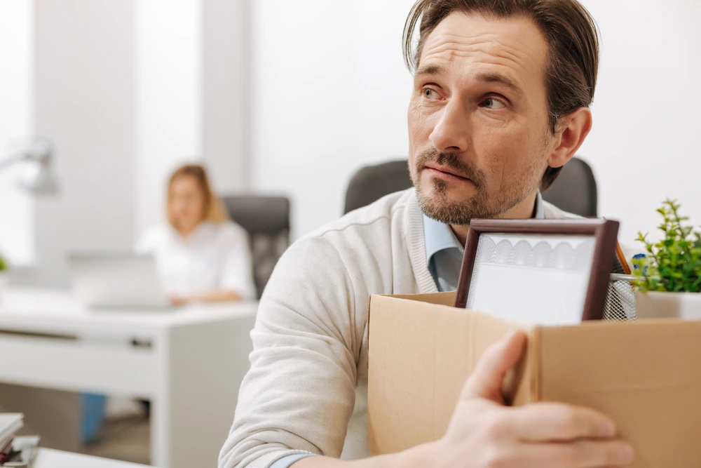 A Fired Employee Holding A Box In The Office.