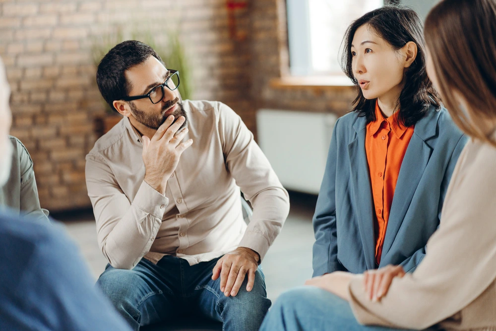 A Group Of Professionals Showing Empathetic Listening During Huddles.