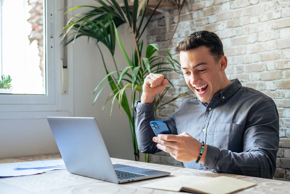 A Man Happily Reading An Employment Offer Letter