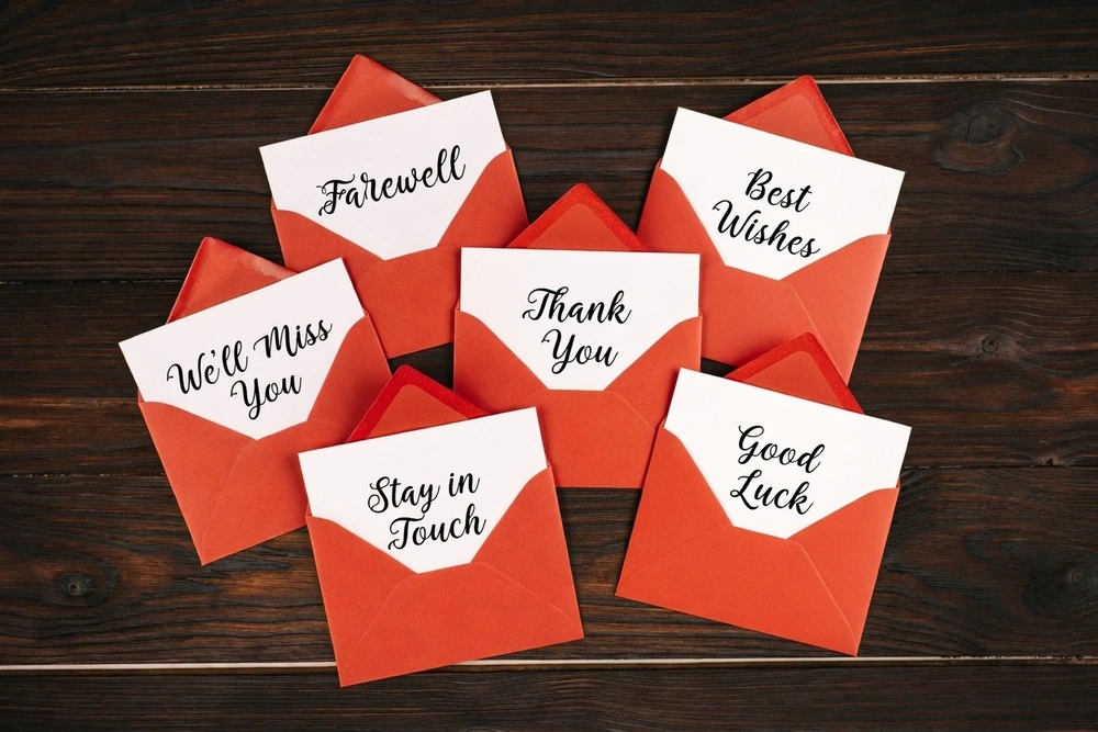 Multiple Envelopes With Farewell Message To Colleagues Laid Out On The Table.
