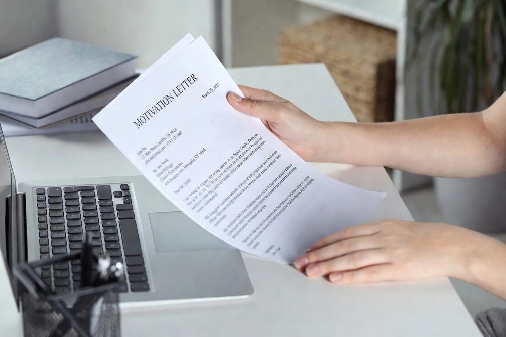 A Cropped View Of An Applicant Holding A Sample Motivation Letter, Illustrating How To Start A Motivation Letter Effectively
